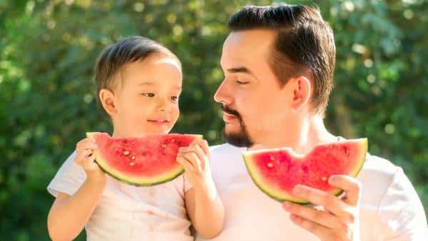 man and son eating watermelon edit