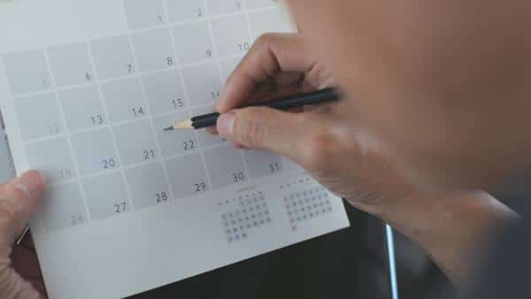 man-marking-a-calendar-with-a-pencil