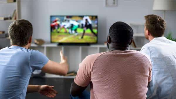 three guys watching sports on tv